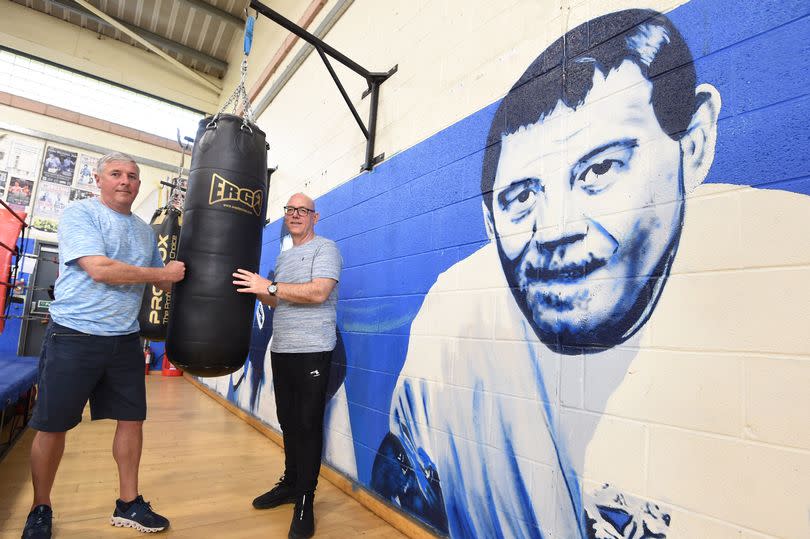 Boxing Coaches Paul Furlong(left),and Andrew Robinson,alongside a mural of his dad and founder of Huyton A.B.C. Brin Furlong