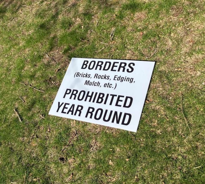 Cedar Hill Cemetery policy sign laying on the cemetery grounds.