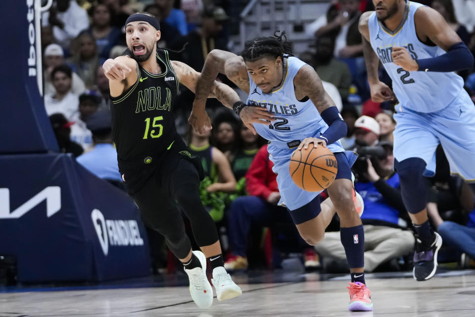 New Orleans Pelicans guard Jose Alvarado (15) tries to cover Memphis Grizzlies guard Ja Morant (12) as he races down court on a turnover in the first half of an NBA basketball game in New Orleans, Tuesday, Dec. 26, 2023. (AP Photo/Gerald Herbert)