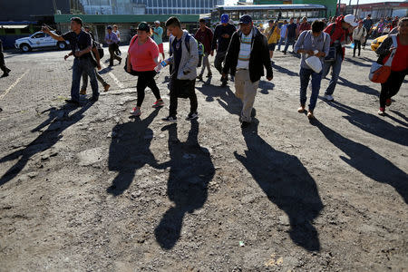 People in a caravan of migrants departing from El Salvador en route to the United States arrive at a bus terminal, in San Salvador, El Salvador, November 18, 2018. REUTERS/Jose Cabezas