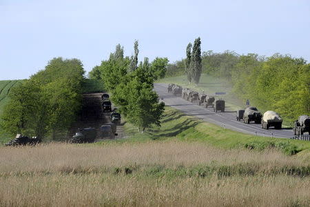 Military vehicles drive along a road at the Russian southern town of Matveev Kurgan, near the Russian-Ukrainian border in Rostov region, Russia, May 24, 2015. Picture taken May 24, 2015. REUTERS/Stringer