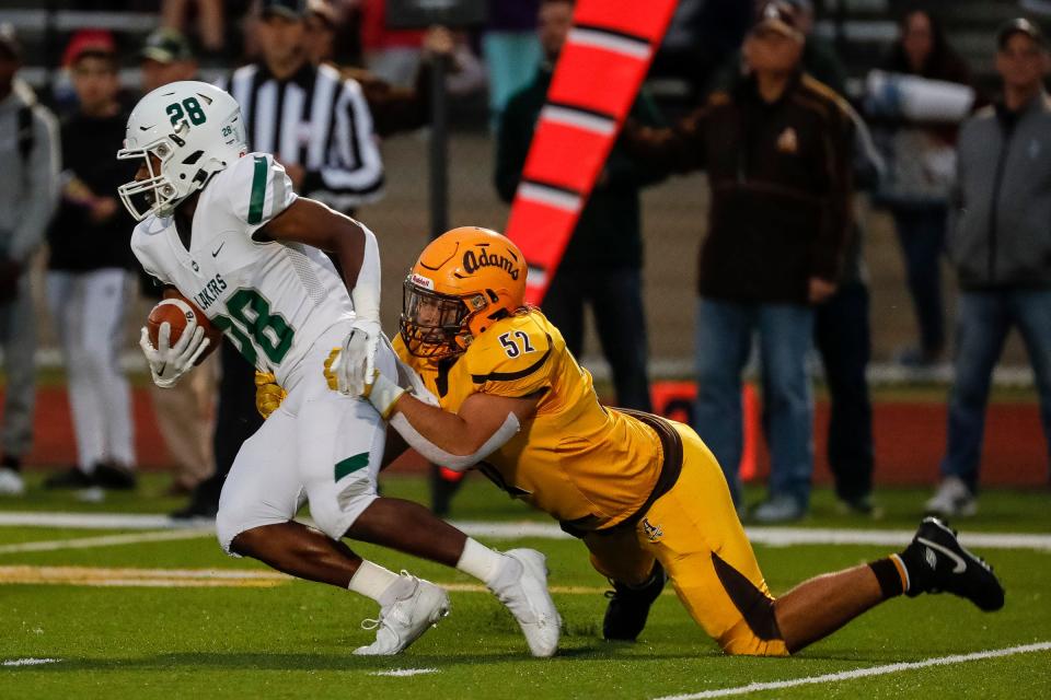 West Bloomfield running back Ralph Rogers (28) runs against Rochester Adams linebacker Rocco Orsini (52) during the first half at Rochester Adams High School in Rochester Hills on Friday, Sept. 23, 2022.