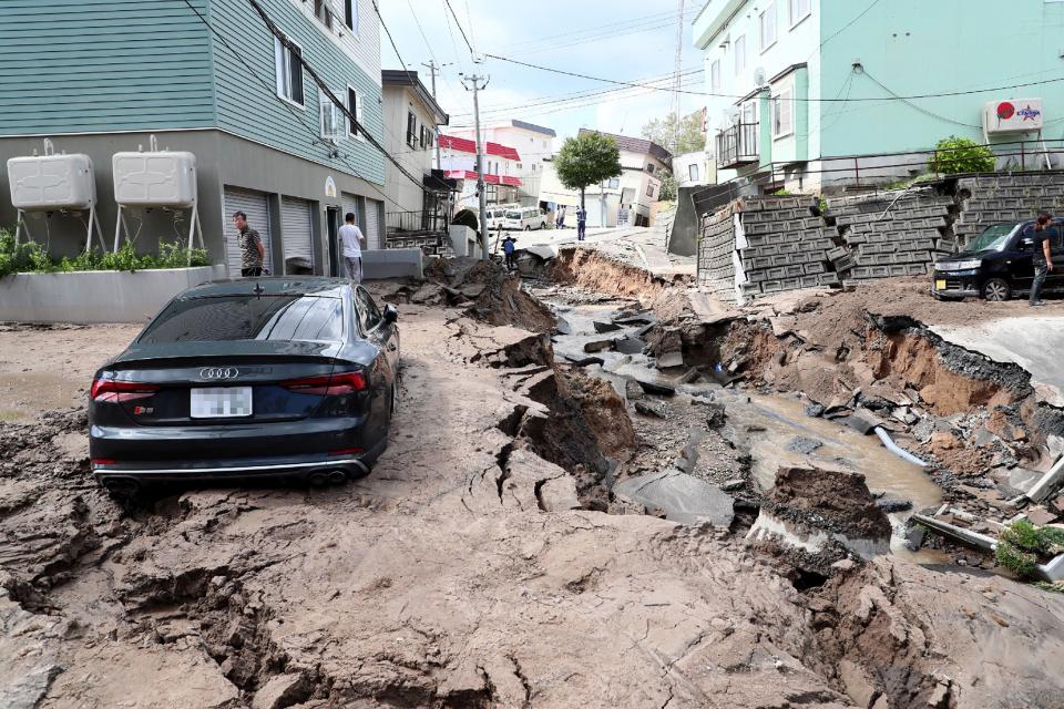 <p>A car is seen stuck on a road damaged by an earthquake in Sapporo, Hokkaido prefecture on September 6, 2018. (Photo: JiJi Press/AFP/Getty Images) </p>