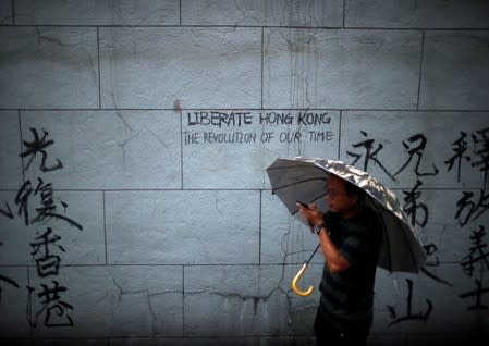 A man walks past a graffiti during a march to demand democracy and political reforms in Hong Kong