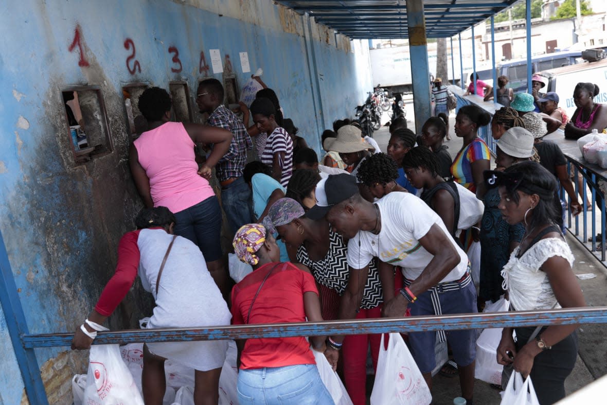 People gather outside the National Penitentiary for their turn to deliver food to their jailed relatives in downtown Port-au-Prince, Haiti, Thursday, June 1, 2023. In December 2022, the University of Florida published a study that found that men in Haiti’s prisons were on a starvation-level diet, consuming fewer than 500 calories a day. (AP Photo/Odelyn Joseph)