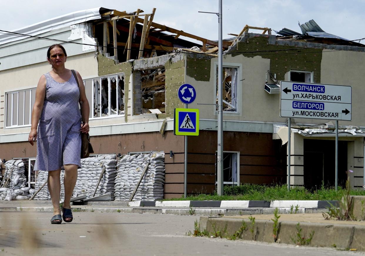 A woman walks in front of a building damaged by strikes in the town of Shebekino, near the Ukrainian border in the Belgorod region (AFP via Getty Images)