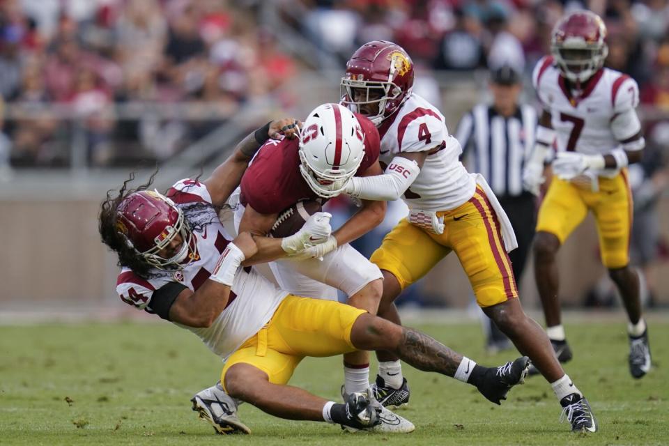 USC linebacker Tuasivi Nomura and defensive back Max Williams tackle Stanford tight end Benjamin Yurosek.