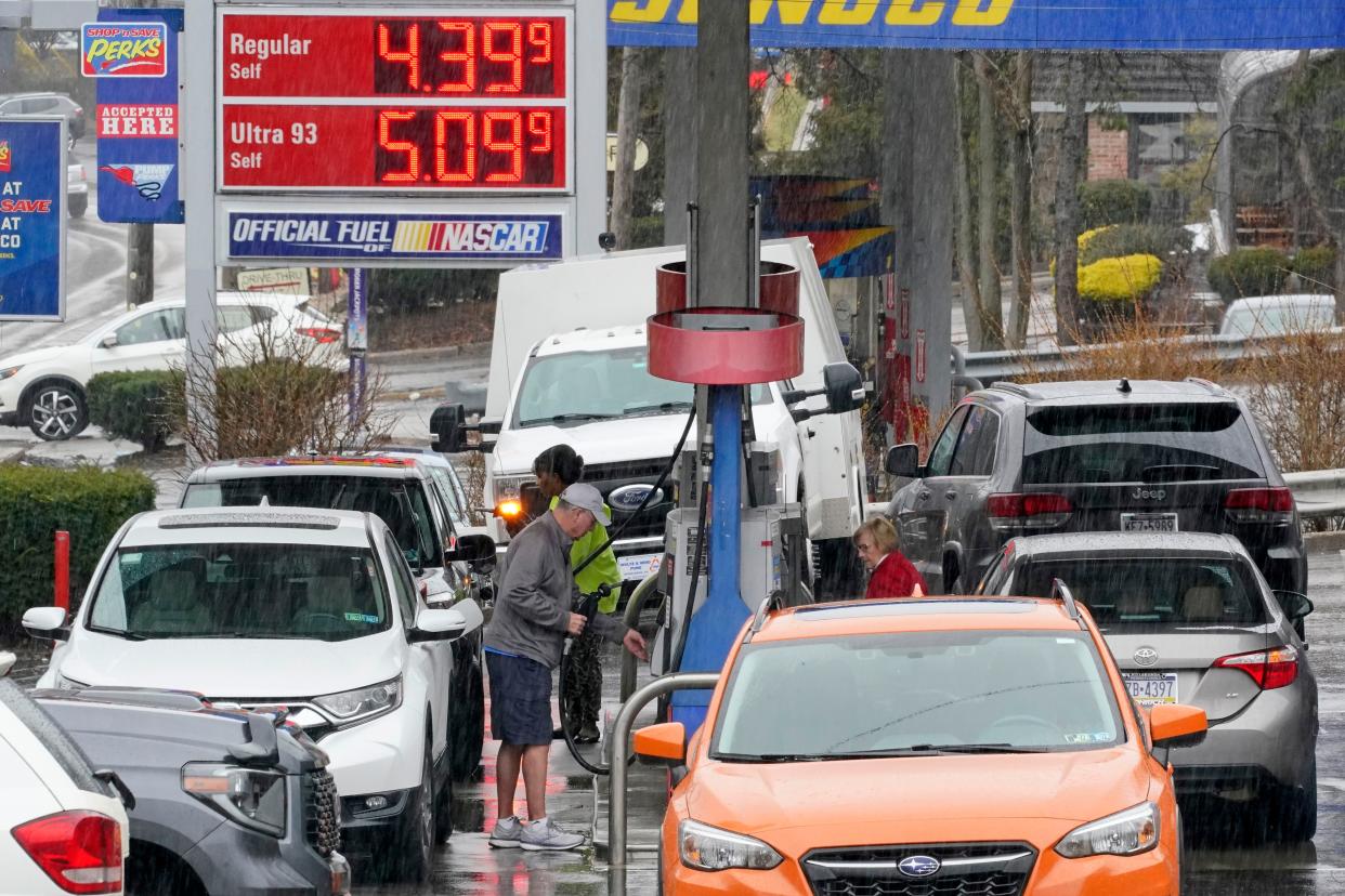 People pump gas at a Giant Eagle GetGo where a gallon of unleaded regular gas is $4.19.9, while at a neighboring Sunoco station, rear, a gallon of unleaded regular is $4.39.9, in Mount Lebanon, Pa., Monday, March 7, 2022.