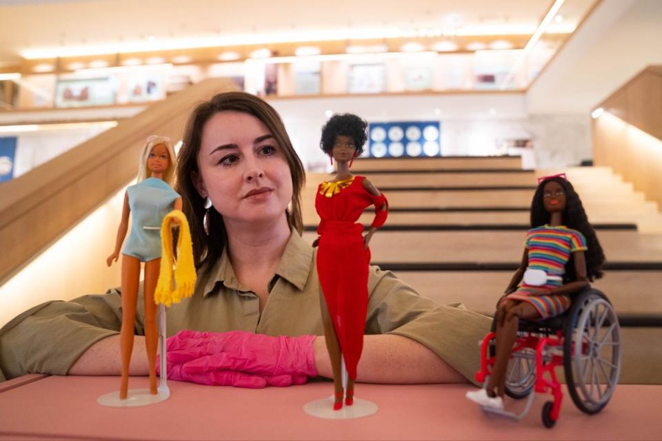 Exhibition curator Danielle Thom stands among Barbie dolls (James Manning/PA Wire)
