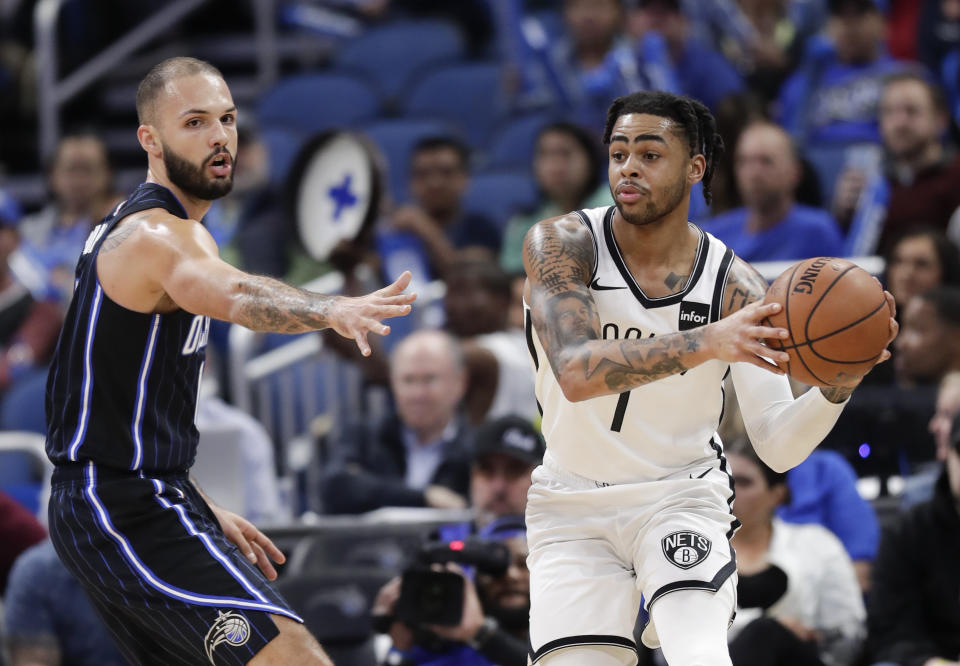 Brooklyn Nets' D'Angelo Russell, right, passes the ball as he Orlando Magic's Evan Fournier defends during the first half of an NBA basketball game Friday, Jan. 18, 2019, in Orlando, Fla. (AP Photo/John Raoux)