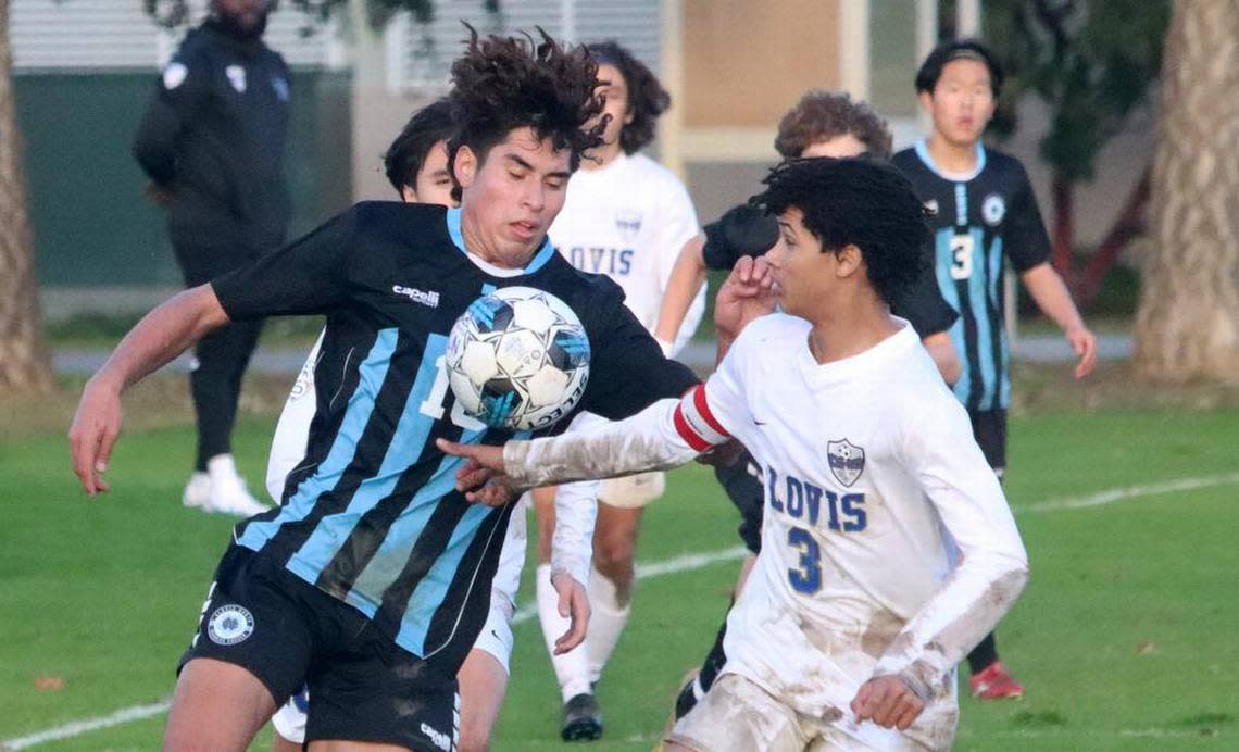 Clovis North senior forward Bryan López gets defended by Clovis High senior Sylas Sells during a TRAC soccer match at Clovis Community College on Jan. 18, 2023. The state’s top-ranked boys team, Clovis North, scored a 2-1 win.