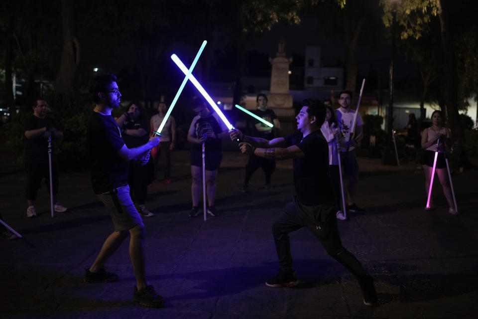 Jedi Knight Academy instructor Ulises Vázquez, known as the Jedi master, right, shows students lightsaber techniques at the public park in Mexico City, late Saturday June 15, 2024. The academy is a lightsaber combat and choreography school founded in 2019 and a dream come true for fans of Star Wars. (AP Photo/Eduardo Verdugo)