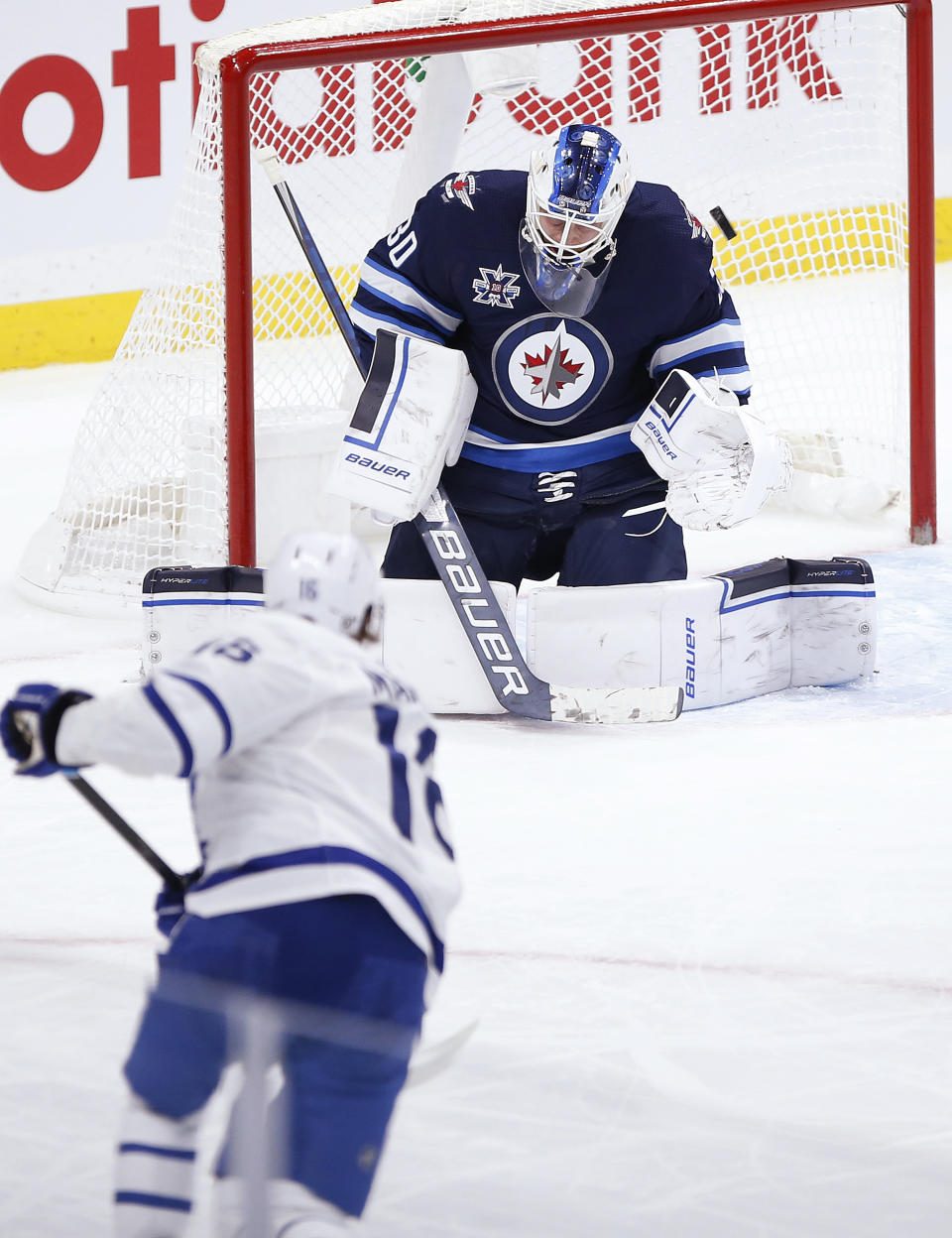 Toronto Maple Leafs' Mitchell Marner (16) scores on Winnipeg Jets goaltender Laurent Brossoit (30) during the second period of an NHL hockey game Thursday, April 22, 2021, in Winnipeg, Manitoba. (John Woods/The Canadian Press via AP)