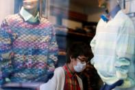 Person in a face mask is seen in a shop in Milan