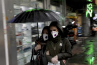 Pedestrians wear masks and gloves to help guard against the Coronavirus in downtown Tehran, Iran, Tuesday, Feb. 25, 2020. The head of Iran's counter-coronavirus task force has tested positive for the virus himself, authorities announced Tuesday, showing the challenges facing the Islamic Republic amid concerns the outbreak may be far wider than officially acknowledged. The announcement comes as countries across the Mideast say they've had confirmed cases of the virus that link back to Iran, which for days denied having the virus. (AP Photo/Ebrahim Noroozi)