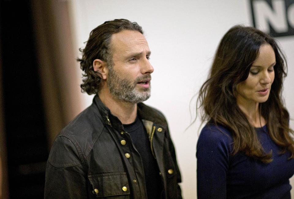 Andrew Lincoln, left, who plays Rick Grimes on the cable TV show "The Walking Dead," walks through Walker Stalker Con, a convention based off the show, with fellow cast member Sarah Wayne Callies, right, Saturday, Nov. 2, 2013, in Atlanta. For Lincoln, acting out the battle scenes in downtown Atlanta during the first season of “The Walking Dead” was a joyous time. Here was the British actor, on the same streets where Confederate forces battled Union troops in the American Civil War, shooting his way through a foreboding urban landscape now over-run by flesh-devouring “walkers.” “It was one of the greatest weekends of my career, you know,” he says, his eyes lighting up with excitement. “We shut down four blocks of downtown Atlanta and I get to ride into the city on a horse. It was epic. (AP Photo/David Goldman)