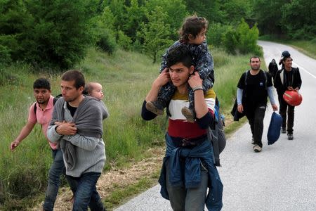 A group of people who tried to cross the border walk back to a makeshift camp for refugees and migrants at the Greek-Macedonian border near the village of Idomeni, Greece, May 11, 2016. REUTERS/Marko Djurica