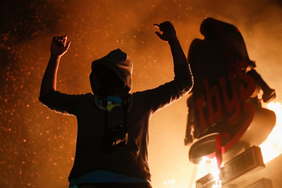 A fast-food restaurant burns near the Minneapolis Police Department's 3rd Precinct station on May 29, 2020. Protests continued for days over the death of George Floyd in police custody.