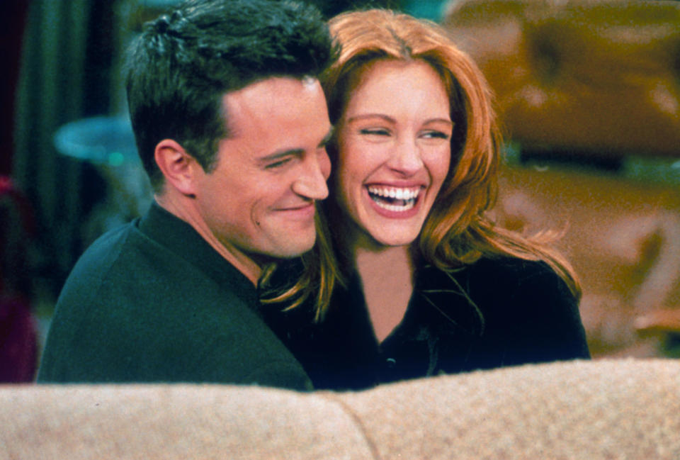 Matthew Perry and actress Julia Roberts hug each other on the set of 