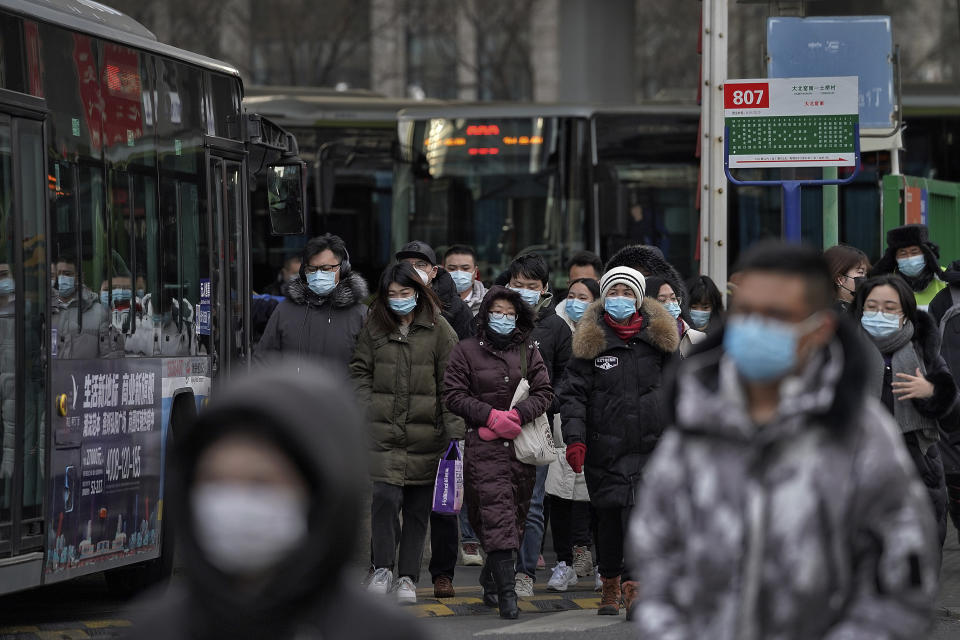 People wearing face masks to help curb the spread of the coronavirus walk out from a bus station for the traveller from the outskirts of Beijing on Monday, Jan. 11, 2012. Chinese health authorities say scores more people have tested positive for coronavirus in Hebei province bordering on the capital Beijing. The outbreak focused on the Hebei cities of Shijiazhuang and Xingtai is one of China's most serious in recent months and comes amid measures to curb the further spread during next month's Lunar New Year holiday. (AP Photo/Andy Wong)