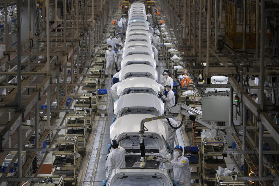 Workers assemble cars at the Dongfeng Honda Automobile Co., Ltd factory in Wuhan in central China's Hubei province on Wednesday, April 8, 2020. Wuhan is a major center for heavy industry, particularly autos, and while many major plants have restarted production after a major disruption due to the coronavirus, the small and midsize businesses that employ the most people are still hurting from both a lack of workers and demand. (AP Photo/Ng Han Guan)