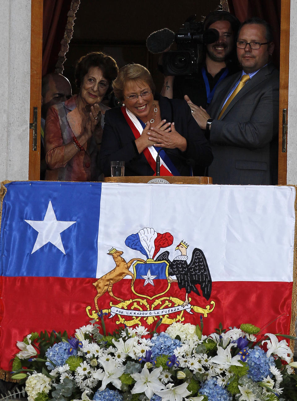 Chile's new President Michelle Bachelet gestures from a balcony at La Moneda presidential palace in Santiago, Tuesday, March 11, 2014. Bachelet, who led Chile from 2006-2010, was sworn-in as president on Tuesday. (AP Photo/Luis Hidalgo).