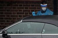 A medical worker carries out a test at a Coronavirus drive-through test centre at Parson's Green Medical Centre in London