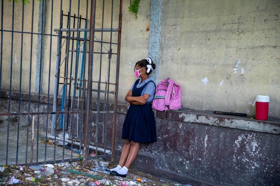 A student waits for her turn to enter the Lycee Marie Jeanne school on the first day back to school since the COVID-19 pandemic in Port-au-Prince, Haiti.