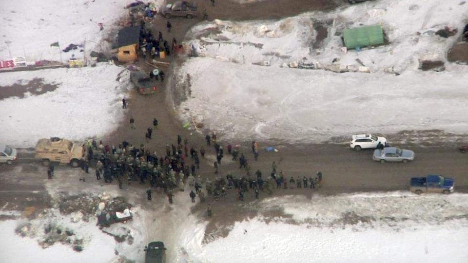 In this Wednesday, Feb. 1, 2017, aerial image taken from a video by KXMB in Bismarck, N.D., law enforcement officers line up against protesters during the eviction of about 40 Dakota Access pipeline opponents from a camp on private property owned by the pipeline developer where the protesters set up on higher ground near their flood-prone main camp in southern North Dakota near Cannon Ball, N.D. Maj. Gen. Malcolm Frost says the Army is following the steps outlined in President Donald Trump's order earlier this month for a fast review of requests to approve the pipeline. (KXMB via AP)