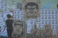 People walk past a wall with a caricature of former Philippine president Gloria Arroyo and Maguindanao massacre suspect Andal Ampatuan at an overpass in Quezon City, east of Manila on November 28, 2011