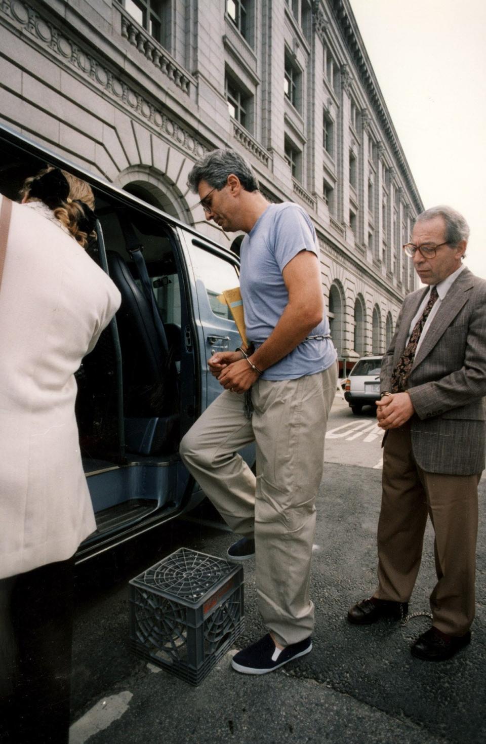 Former Pawtucket Mayor Brian Sarault in handcuffs outside federal courthouse. He was arrested on June 12, 1991 on racketeering charges, as federal investigators charged he and two aides ran a bribe and kickback operation from City Hall.