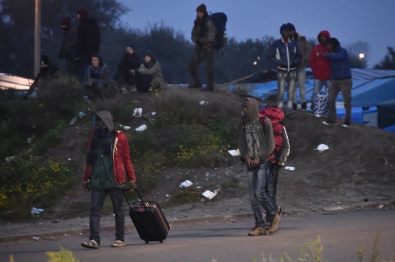 Dès l’aube, des migrants, bagages à la main, quittent les lieux pour rejoindre le centre de transit, dont l’ouverture est prévue à 08h00. (AFP)