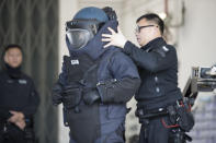 A police officer from the bomb disposal squad putting on protective gear during a demonstration for media in Hong Kong, Friday, Dec. 6, 2019. Hong Kong's much-maligned police force provided a rare behind-the-scenes look Friday at its bomb disposal squad to show the potentially deadly destructive force of homemade explosives seized during months of protests that have shaken the Chinese territory. (AP Photo/Vincent Thian)