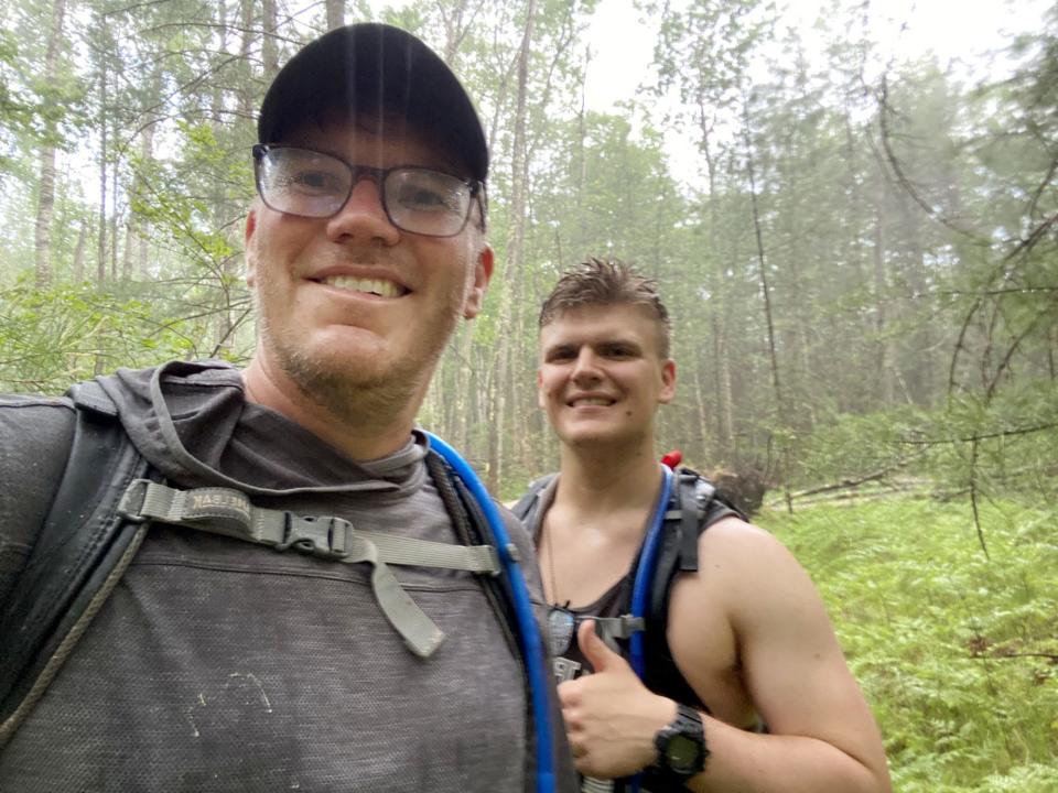 Jim Pool, left, and his son, Elijah, in the rain during their 52-mile hike in the Manistee National Forest in the northern part of the Lower Peninsula.