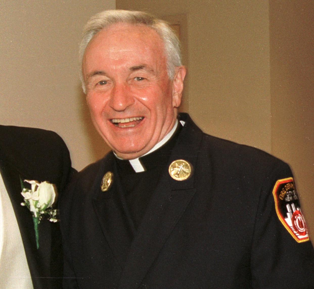 Fire Department chaplain Rev. Mychal Judge smiles for a photograph July 28, 2001. 