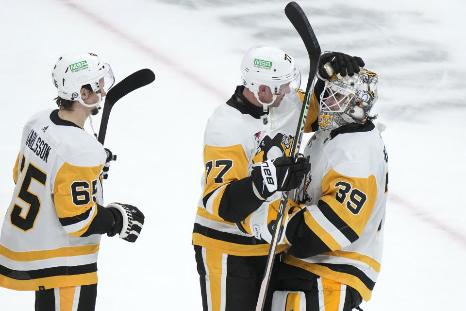 Pittsburgh Penguins defenseman Erik Karlsson (65) and center Jeff Carter (77) celebrate with goaltender Alex Nedeljkovic (39) after defeating the Boston Bruins in a NHL hockey game, Thursday, Jan. 4, 2024, in Boston. (AP Photo/Steven Senne)