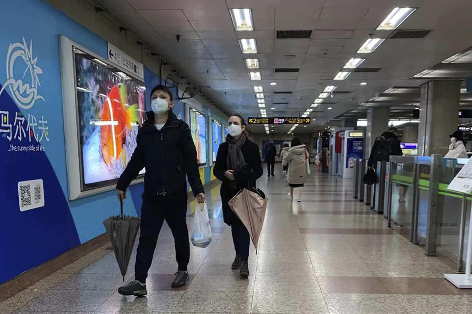 Unas personas usando un cubrebocas caminan por una estación de metro desierta en Shanghai, China, el domingo 26 de enero de 2020, mientras persiste el temor por el coronavirus. (Foto AP/Erika Kinetz)