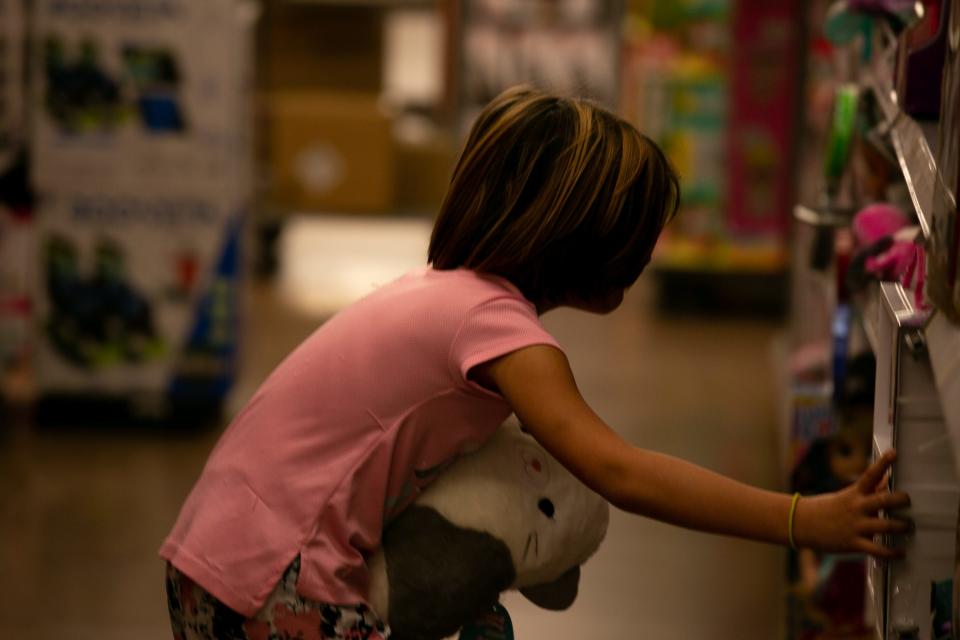 A Sinton Elementary student holds a Squishmallows toy while looking at other toys at the Walmart in Portland on Saturday, Dec. 10, 2022. The elementary student was able to purchase clothes and toys courtesy of the nonprofit Sinton for Youth.