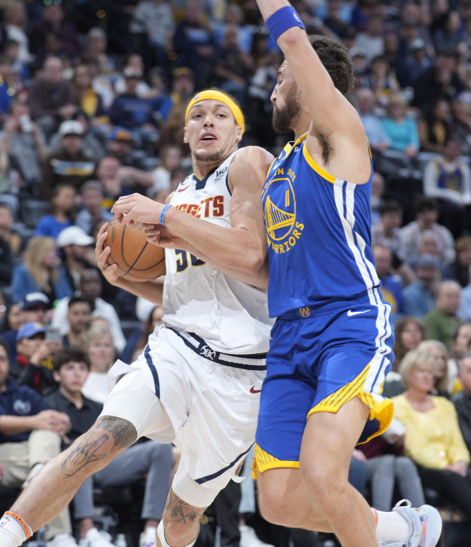 Denver Nuggets forward Aaron Gordon, left, drives to the rim as Golden State Warriors guard Klay Thompson defends in the first half of an NBA basketball game, Sunday, April 2, 2023, in Denver. (AP Photo/David Zalubowski)