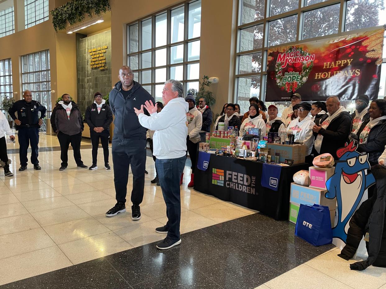 NBA legend Earvin "Magic" Johnson and Carlos Latour, General Motors director of dealer diversity, deliver a few words before distribution begins for a giveaway hosted by Johnson and General Motors at Second Ebenezer Church in Detroit on Nov. 12, 2022.