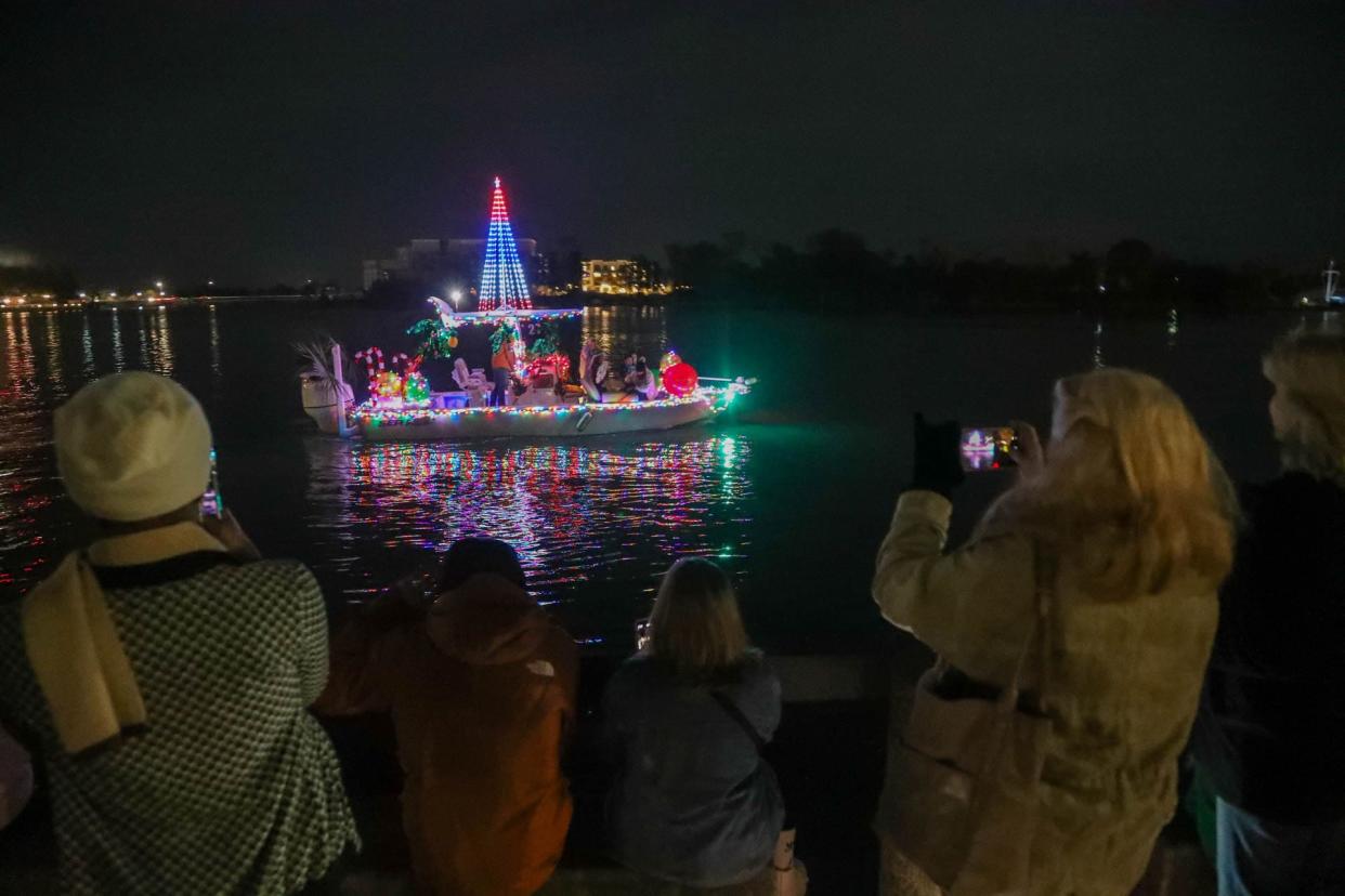 Onlookers take photos and video as the Savannah Boat Parade of Lights passes on Saturday, November 25, 2023.