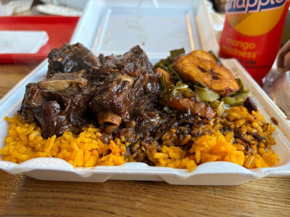 Island Grill & Pub’s small oxtail plate made with collard greens, plantains, yellow rice and gravy.