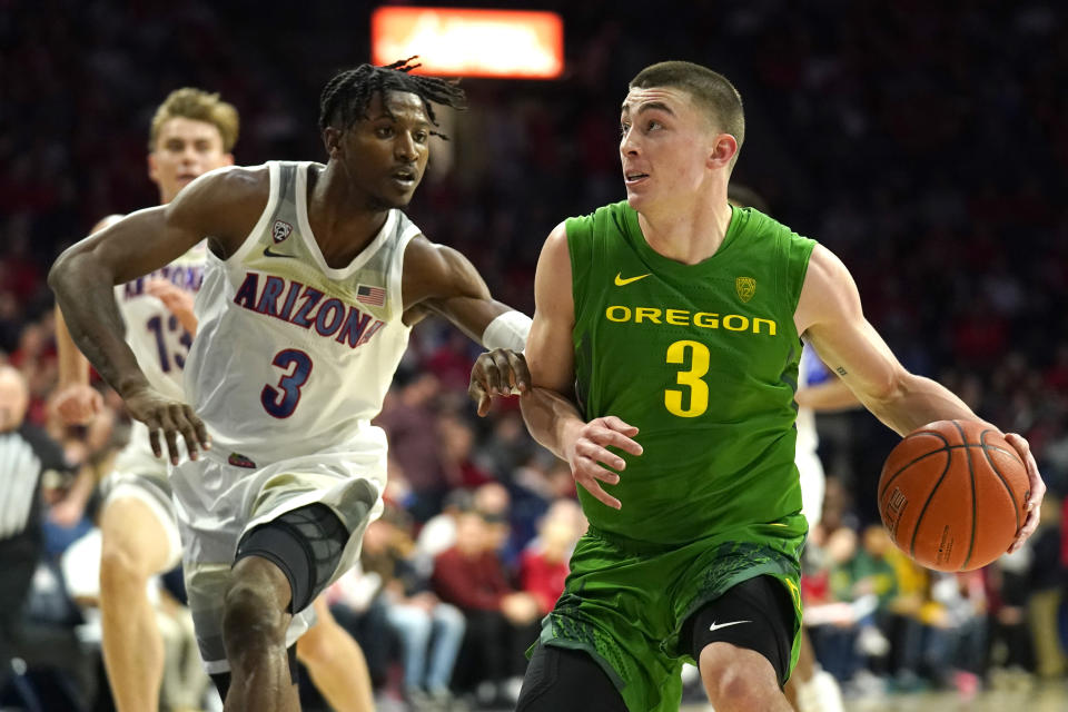 Oregon guard Payton Pritchard, right, drives on Arizona guard Dylan Smith during the first half of an NCAA college basketball game Saturday, Feb. 22, 2020, in Tucson, Ariz. (AP Photo/Rick Scuteri)