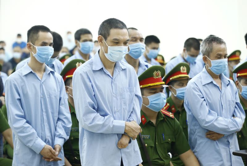 Farmers of Dong Tam village stand between police during court verdict in Hanoi