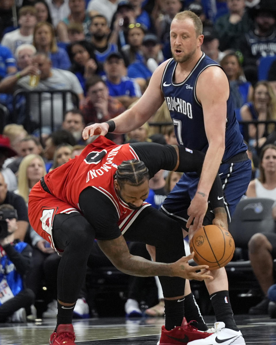 Chicago Bulls center Andre Drummond, left, loses control of the ball as he tries to move against Orlando Magic guard Joe Ingles (7) during the first half of an NBA basketball game, Sunday, April 7, 2024, in Orlando, Fla. (AP Photo/John Raoux)