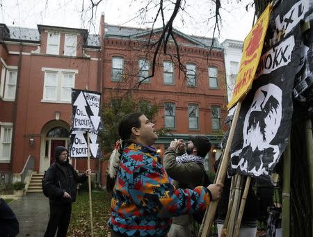 Wica Agli, a member group in the Cowboy Indian alliance, co-founder Aldo Seoane (C), gathers protest signs against the Keystone XL pipeline in front of the home of U.S. Senator Mary Landrieu (D-LA), chair of the Senate Energy Committee, in in Washington November 17, 2014. REUTERS/Gary Cameron