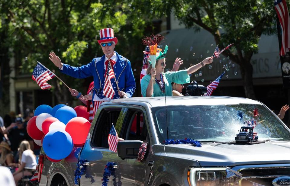 A truck from Price Ford carries Uncle Sam and Lady Liberty during the Turlock 4th of July parade on Main Street in Turlock Calif., on Saturday, July 2, 2022.