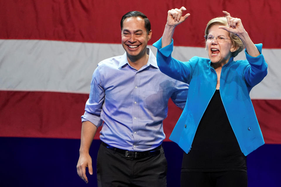 Julian Castro smiles as Elizabeth Warren speaks at her rally in Brooklyn, N.Y., on Tuesday. (Carlo Allegri/Reuters)