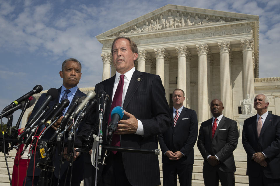 Texas Attorney General Ken Paxton, center, with District of Columbia Attorney General Karl Racine, left, and a bipartisan group of state attorneys general speaks to reporters in front of the U.S. Supreme Court in Washington, Monday, Sept. 9, 2019 on an antitrust investigation of big tech companies. (AP Photo/Manuel Balce Ceneta)