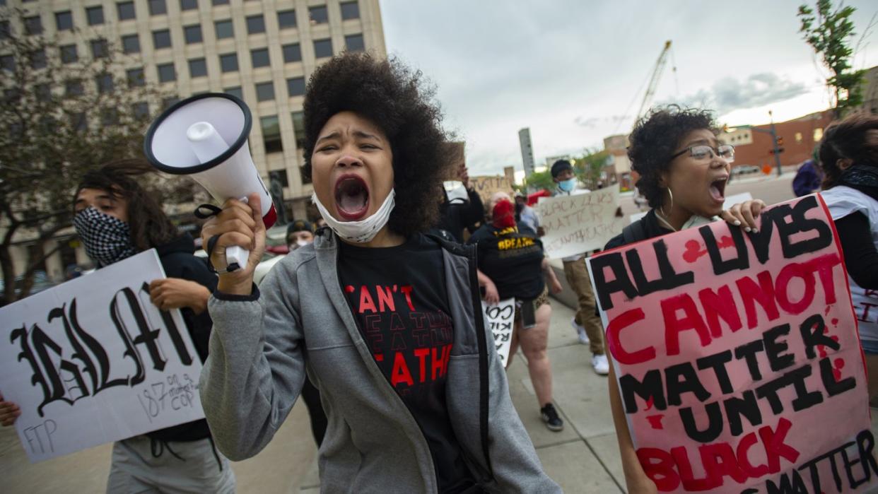 Shayana Dabney (l.) führt während eines Protestes in Colorado Springs eine Gruppe von Demonstranten mit einem Megafon durch die Innenstadt.